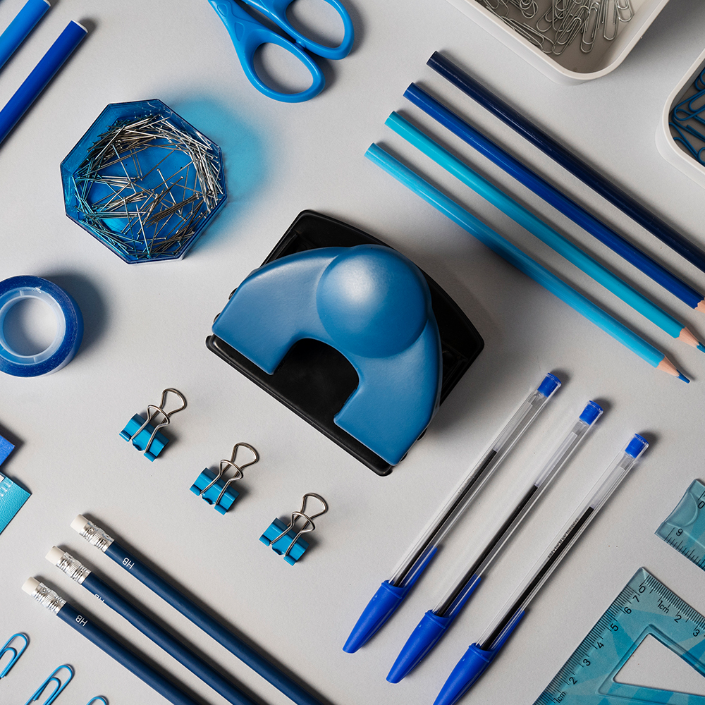 Top view of various office supplies organized neatly on a plain surface