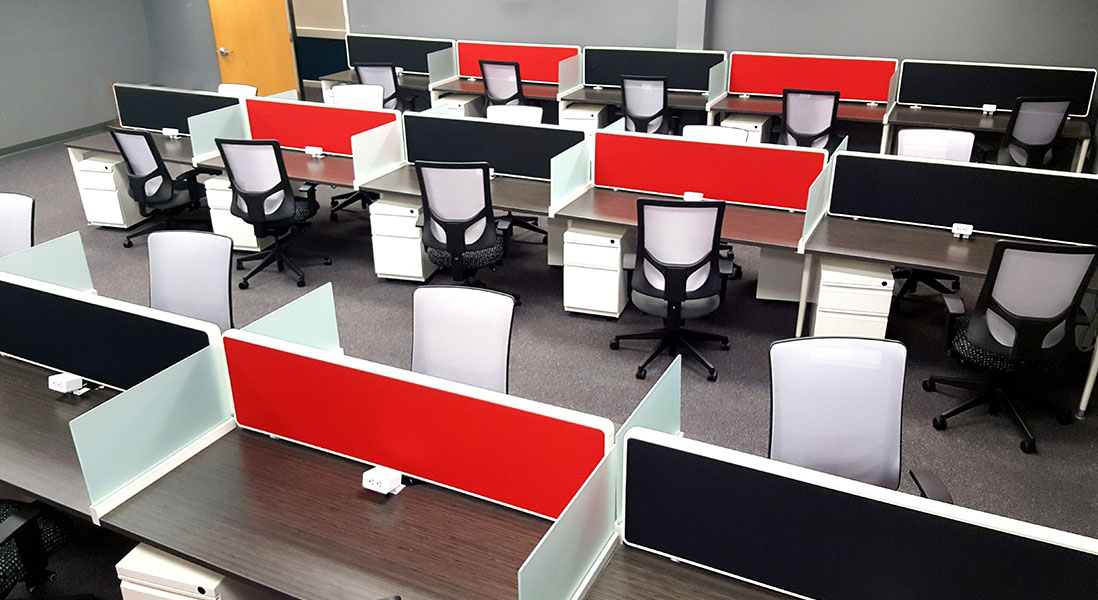 Large modern office space with lots of employee work stations or student study stations with modular dividers, rolling file cabinets and ergonomic chairs