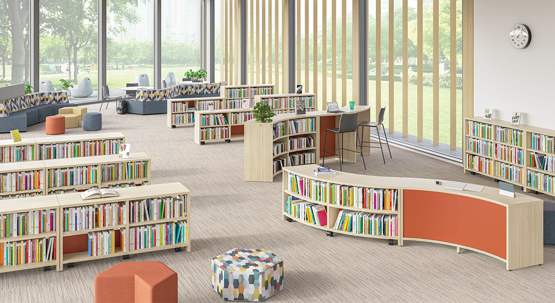 MCM Library children's section with fun curved bookshelves and various shapes for seating with taller work stations for adults