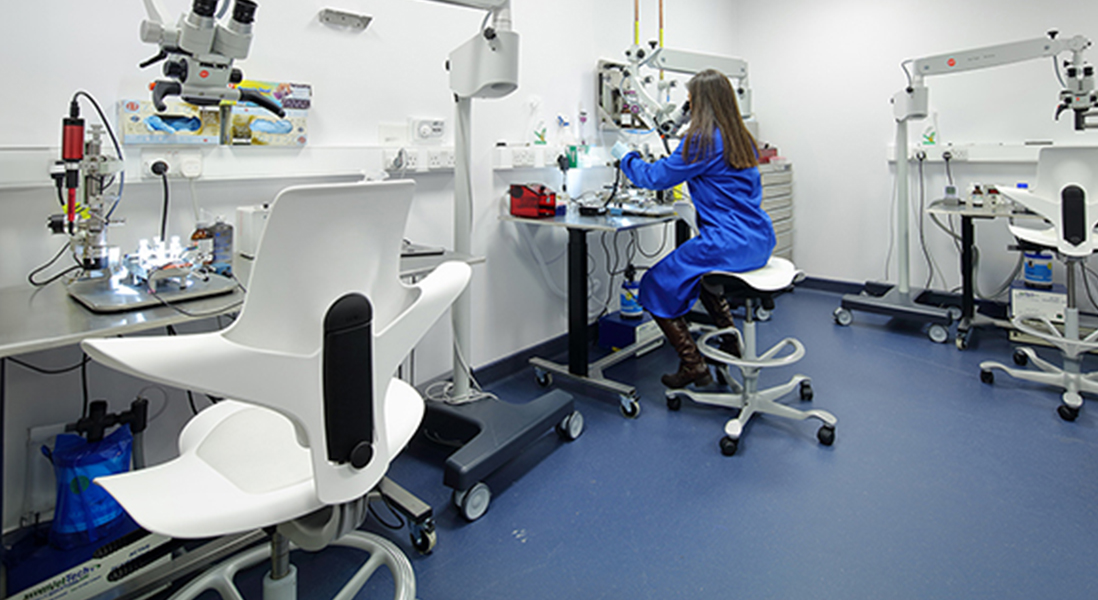 Laboratory setting with ergonomic adjustable height chairs for forward or backward sitting with arm rests and easy to clean surfaces