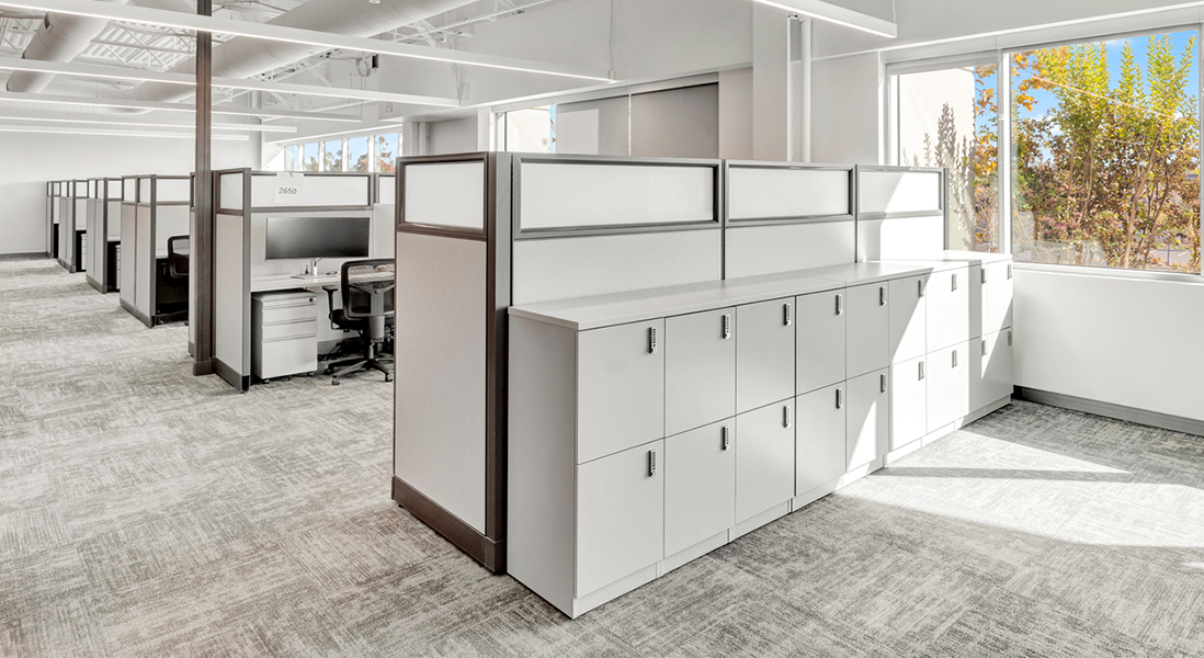 Large modern office space with cubicles made from modular walls, featuring locking storage cabinets