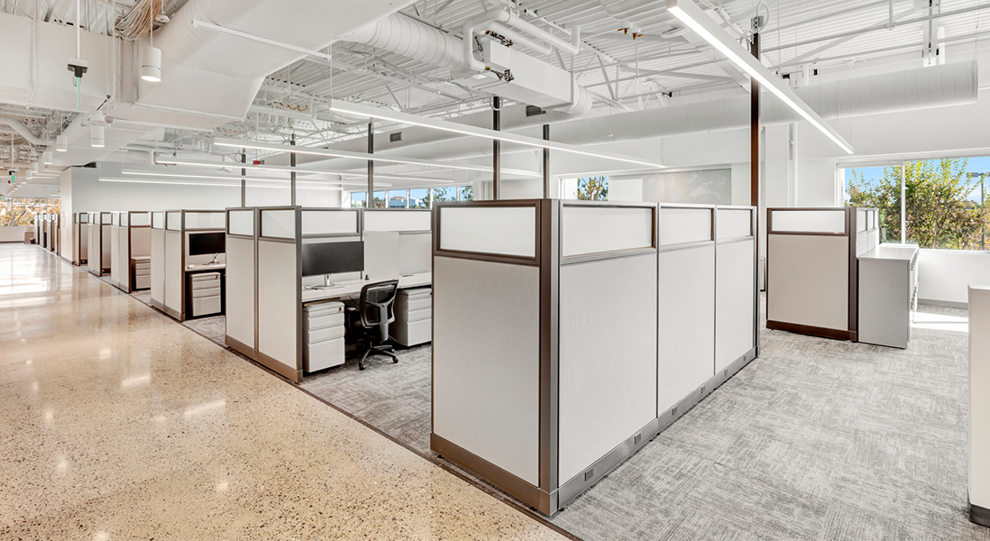 Large modern office space hallway with co-working stations made from modular walls, moveable storage and ergonomic chairs