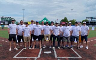 Group photo of people wearing "Live United" t-shirts on a baseball field at a United Way event